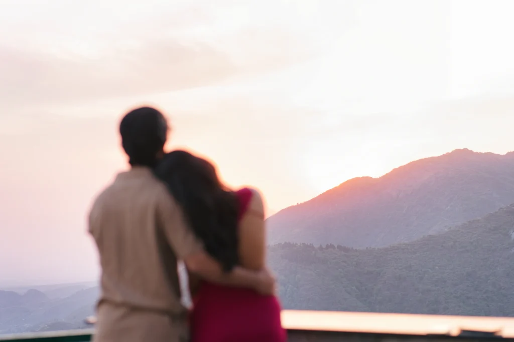 Proposal photography in Mussoorie capturing a couple embracing against scenic mountain views