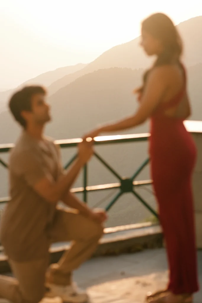 Heartwarming proposal moment with a couple sharing a kiss at sunset