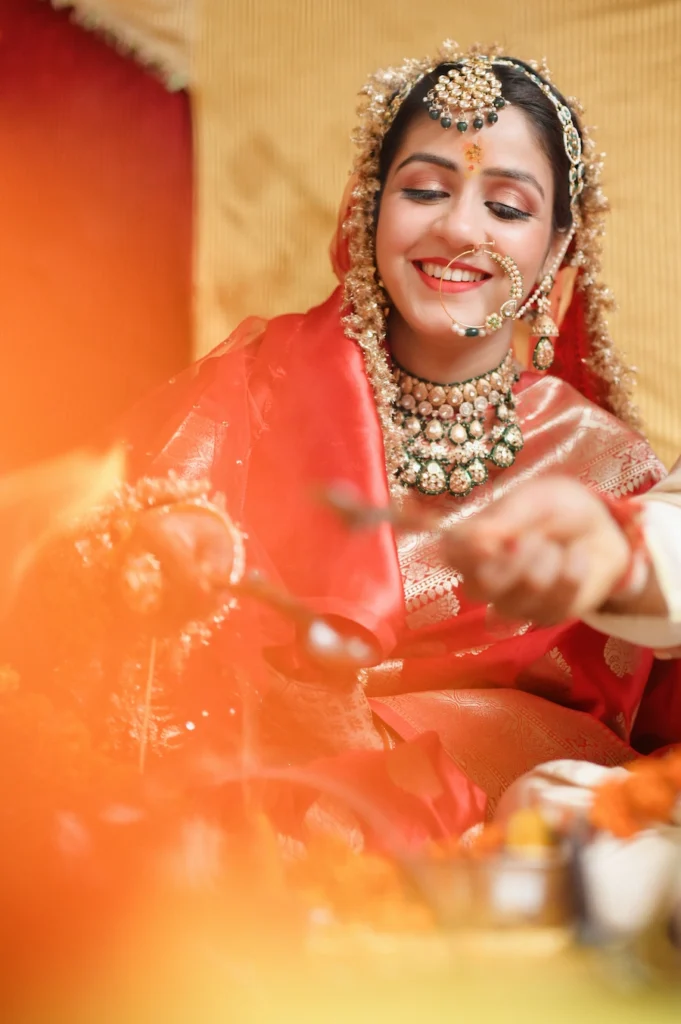 Bride smiling during a sacred wedding ritual with glowing firelight