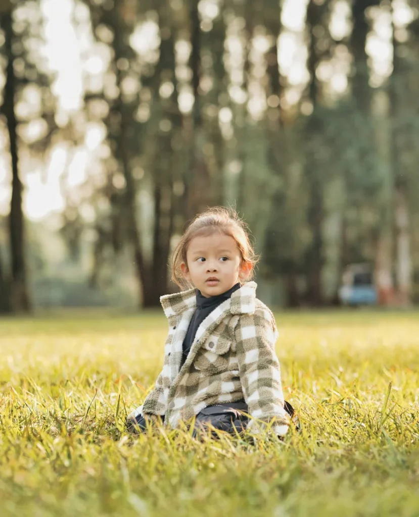 Toddler sitting on green grass during a Birthday Shoot in Mussoorie