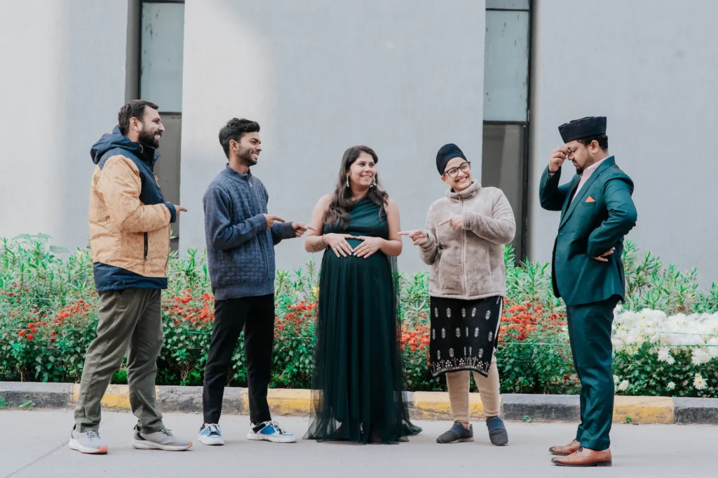 Friends and family sharing joyful moments with expecting parents during a pregnancy photoshoot celebration
