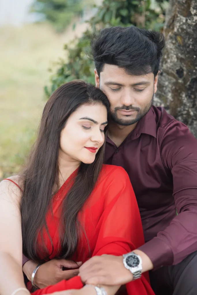 Intimate portrait of a couple sitting together beneath a tree.