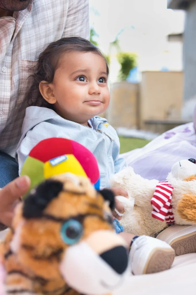 First Birthday portrait of baby Jiyansh surrounded by toys during an outdoor celebration
