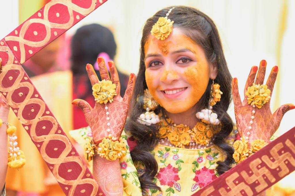 Bride showing floral jewelry and mehndi during the haldi ceremony