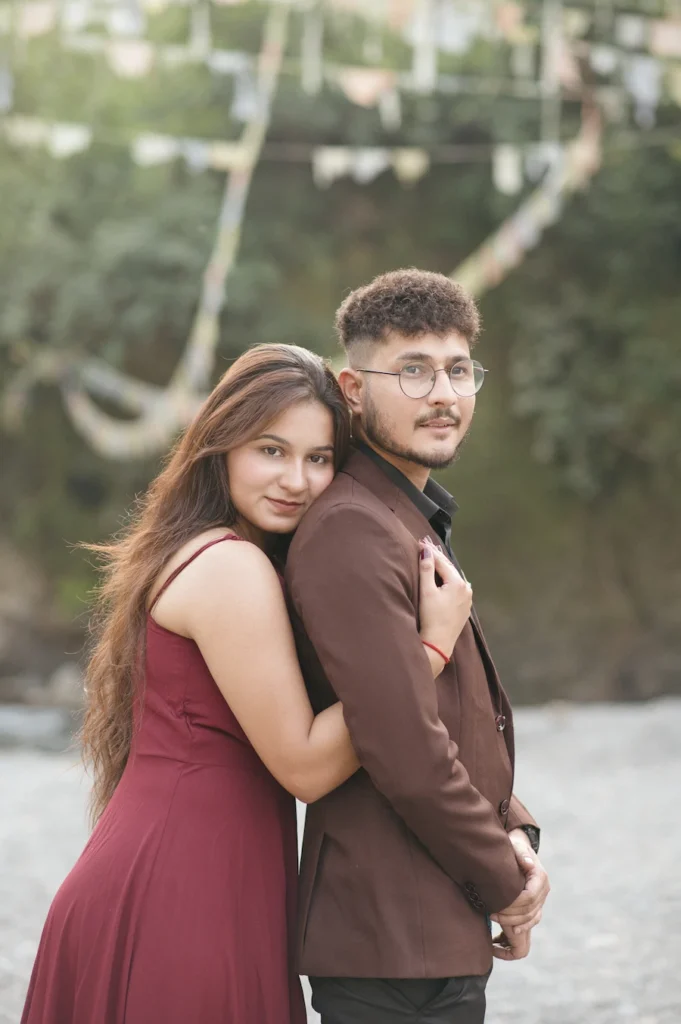 Romantic couple embracing during a golden hour pre-wedding photoshoot in a scenic outdoor location.