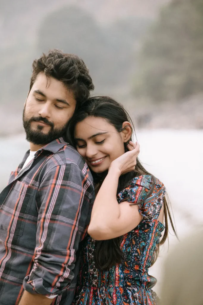 Close-up portrait of a couple sharing a quiet embrace with natural smiles and an intimate connection