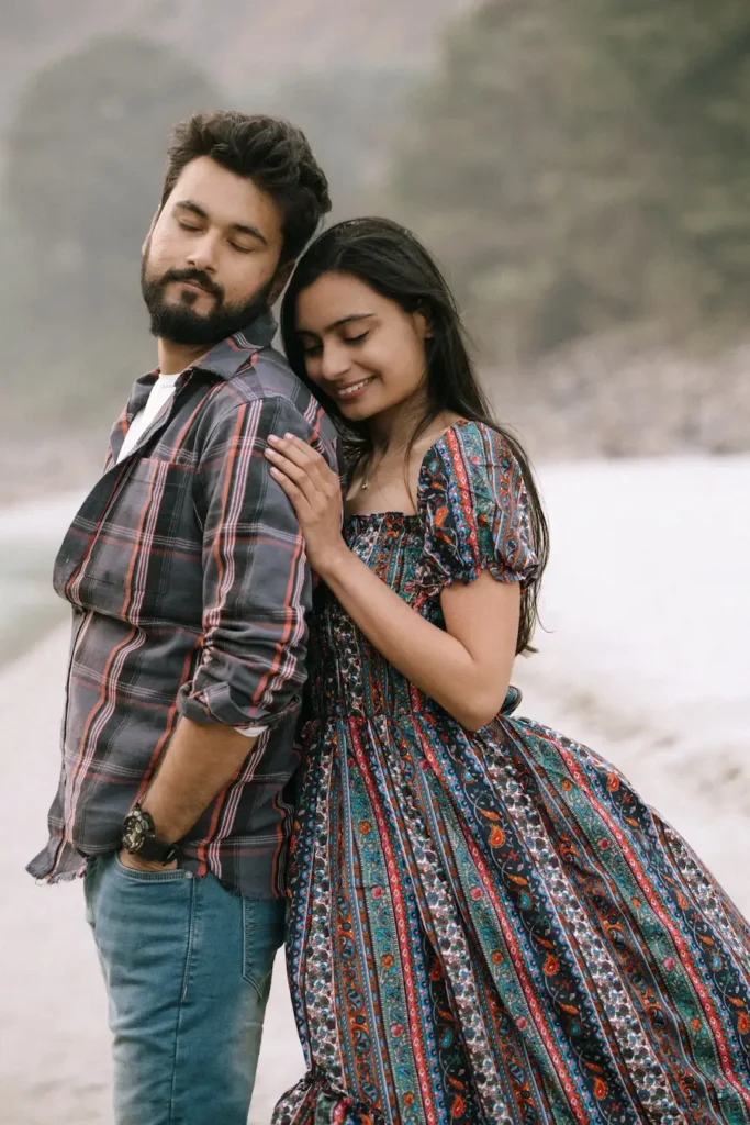 Candid portrait of a couple leaning on each other beside a calm river in a peaceful outdoor setting