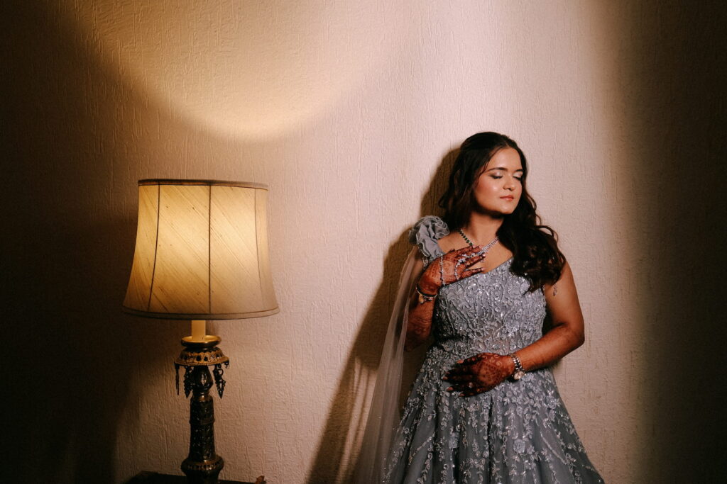 Wedding bridal portrait in elegant gown with creative indoor lighting and candid pose