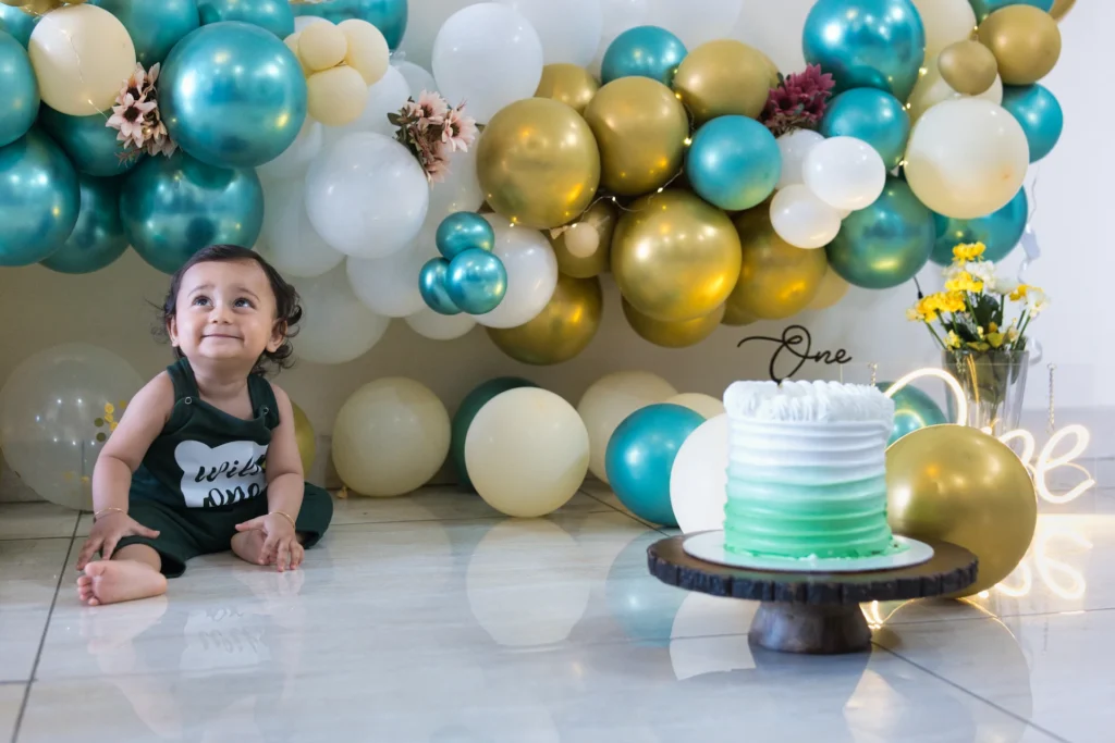 First Birthday cake smash setup featuring baby Jiyansh with colorful balloons and birthday cake
