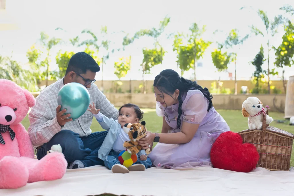 First Birthday family picnic photoshoot of baby Jiyansh playing with his parents and colorful balloons