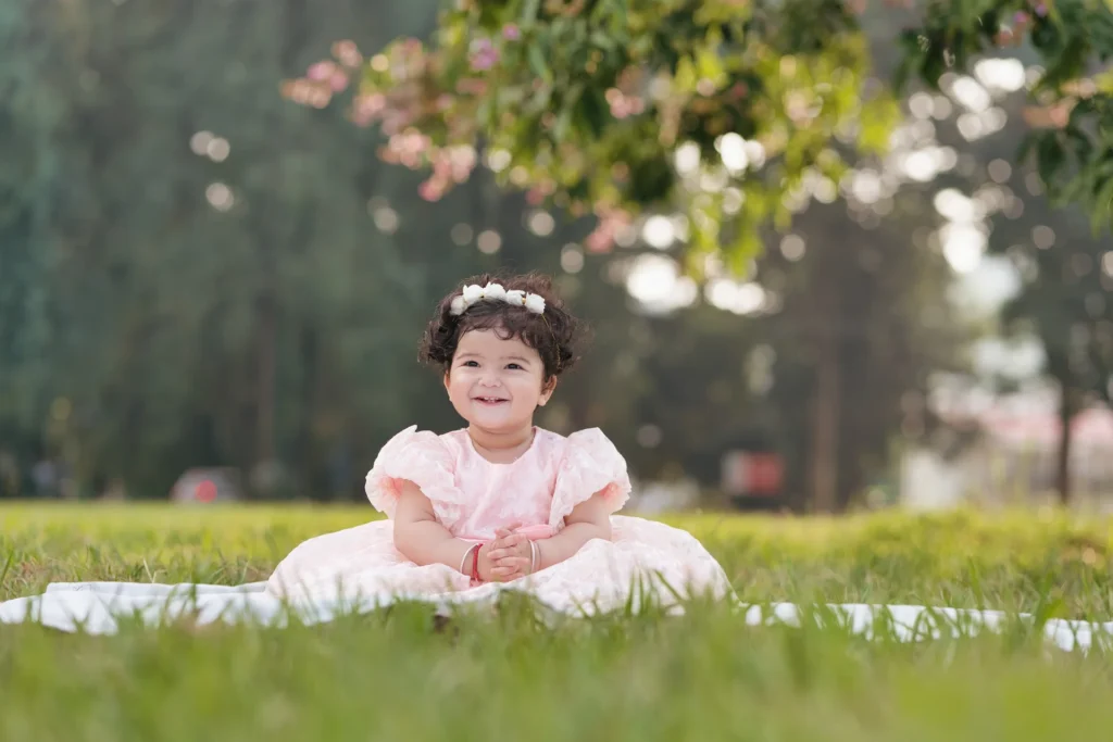 Adorable baby sitting on lush green grass during a Birthday Shoot in Mussoorie