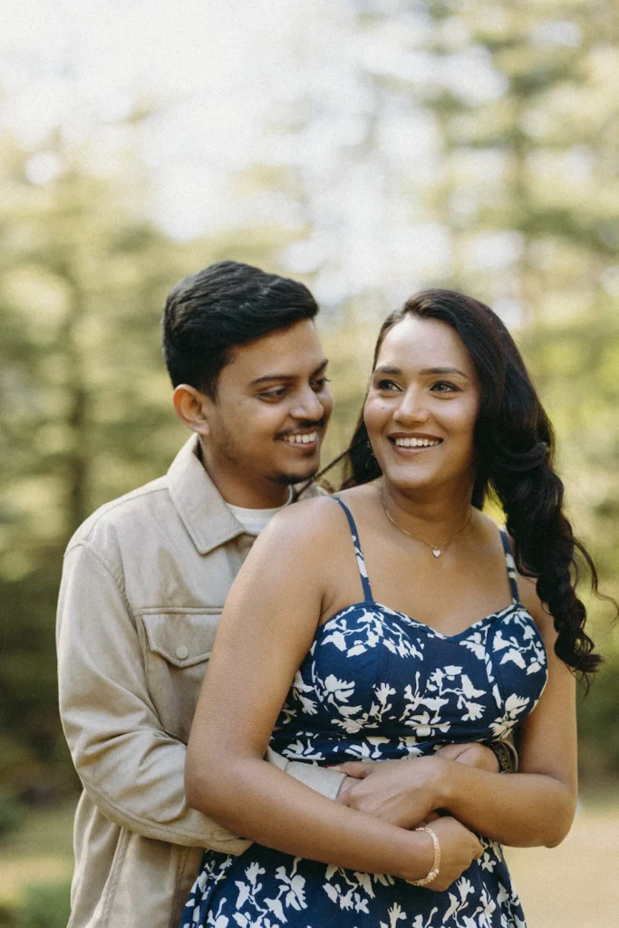 Happy couple sharing a candid embrace during a natural outdoor pre-wedding photography session.