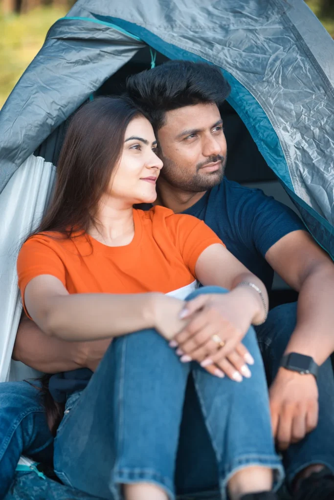 Couple sitting inside a tent enjoying a peaceful camping experience.