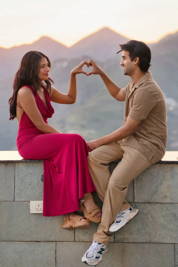 Best Wedding Photographer capturing a romantic sunset engagement couple creating a heart shape with their hands during a pre-wedding photoshoot