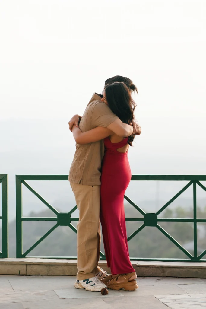 Couple sharing a warm hug with scenic mountain views in the background