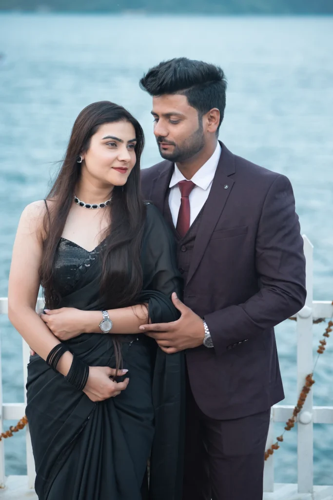 Elegant portrait of a formally dressed couple beside the water.
