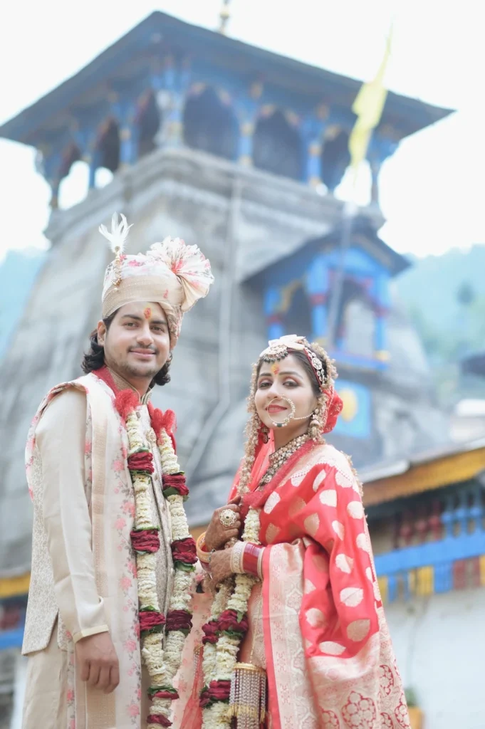 Newlywed couple posing in front of Triyuginarayan Temple after their wedding ceremony