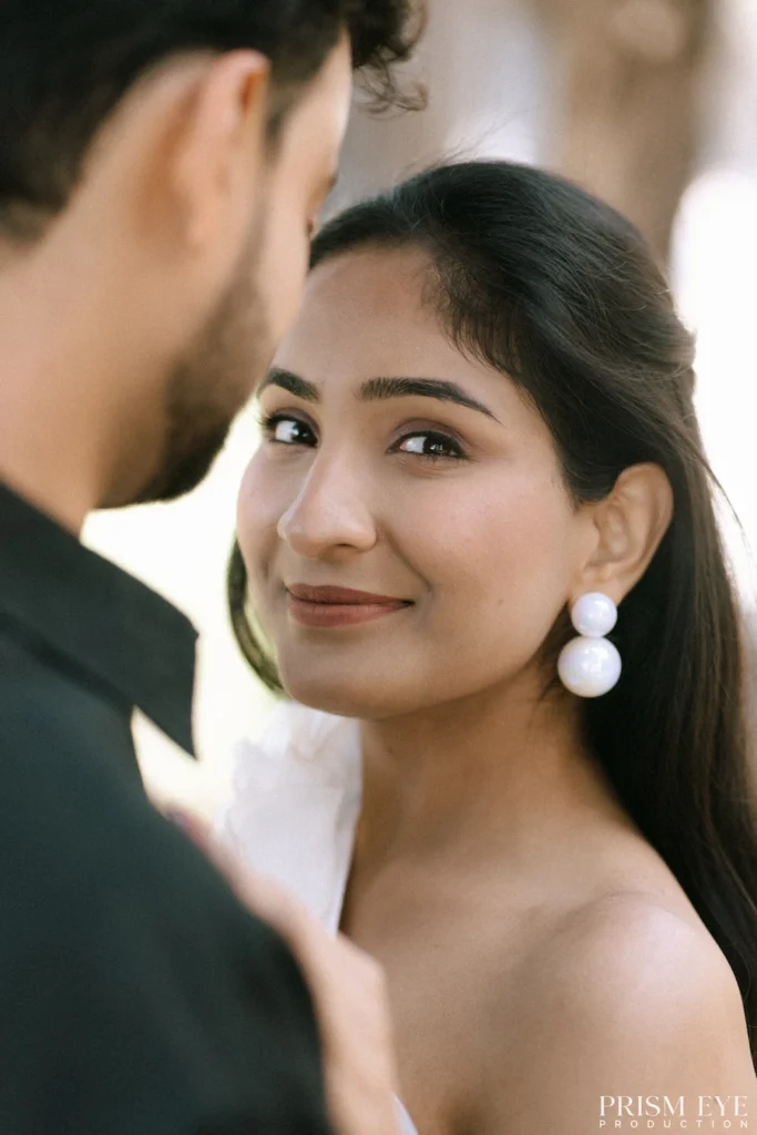 Bride smiling naturally while sharing a candid moment during an engagement celebration.