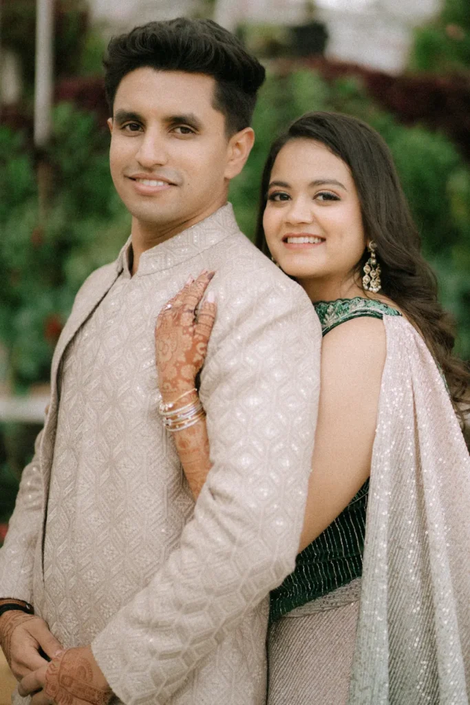 Happy couple posing together during their engagement ceremony in traditional attire.