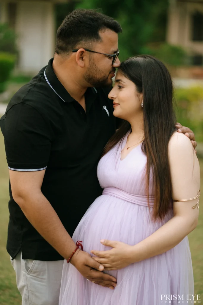 Romantic portrait of an expecting couple sharing a tender forehead kiss during a maternity session.