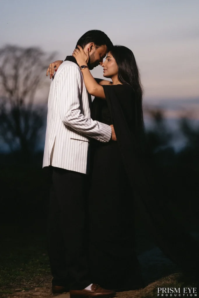 Romantic couple embracing at dusk during a cinematic pre-wedding photoshoot.