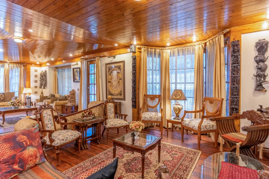 Elegant luxury living room featuring classic wooden interiors, premium furniture, and warm ambient lighting.