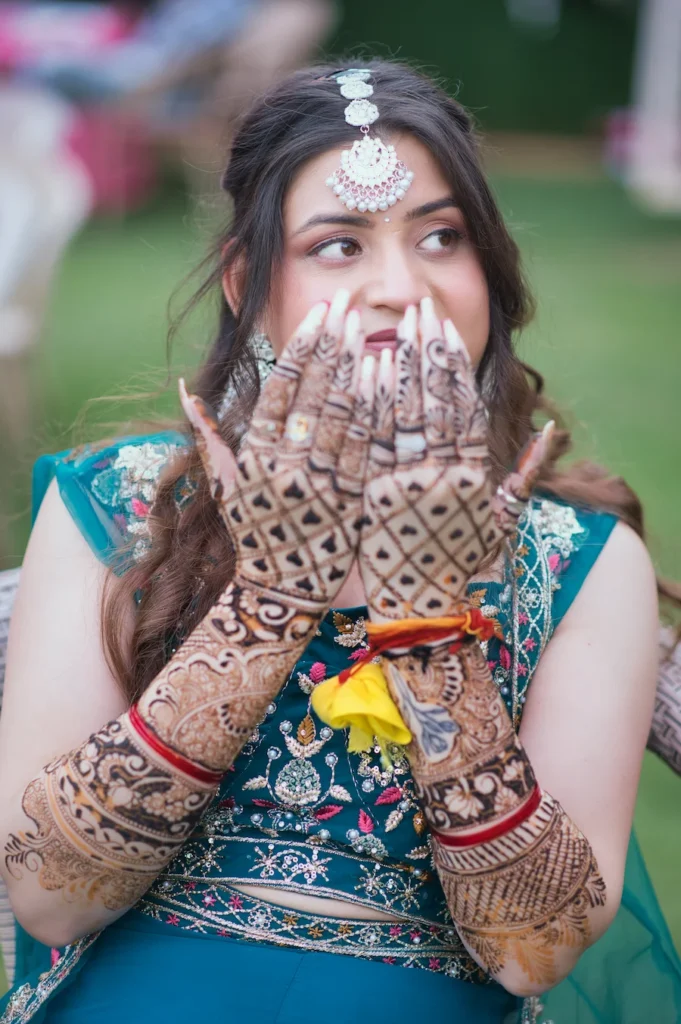 Bride admiring her intricate mehndi design before the wedding celebration.