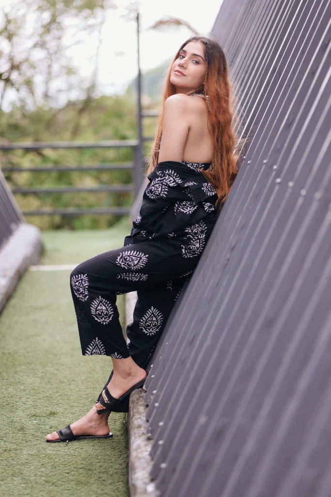 Lifestyle portrait of a woman leaning against a contemporary building in a black co-ord set.