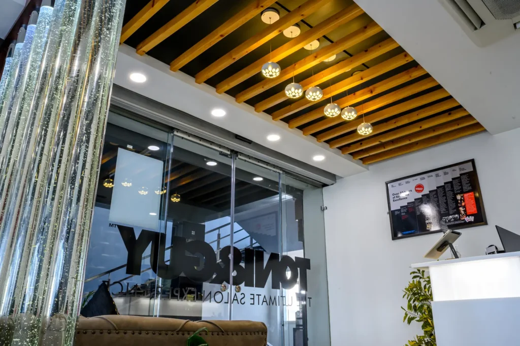 Modern salon reception area with contemporary ceiling design, glass entrance, and stylish interior décor.
