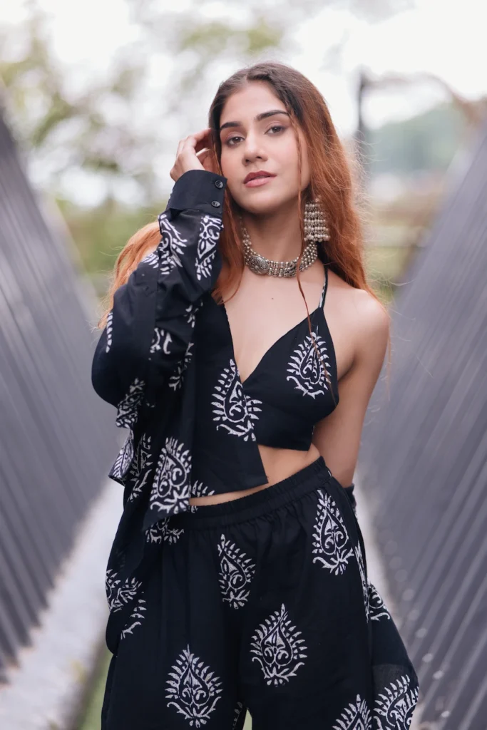 Modern fashion portrait featuring a woman in a black ethnic co-ord set with statement jewelry.