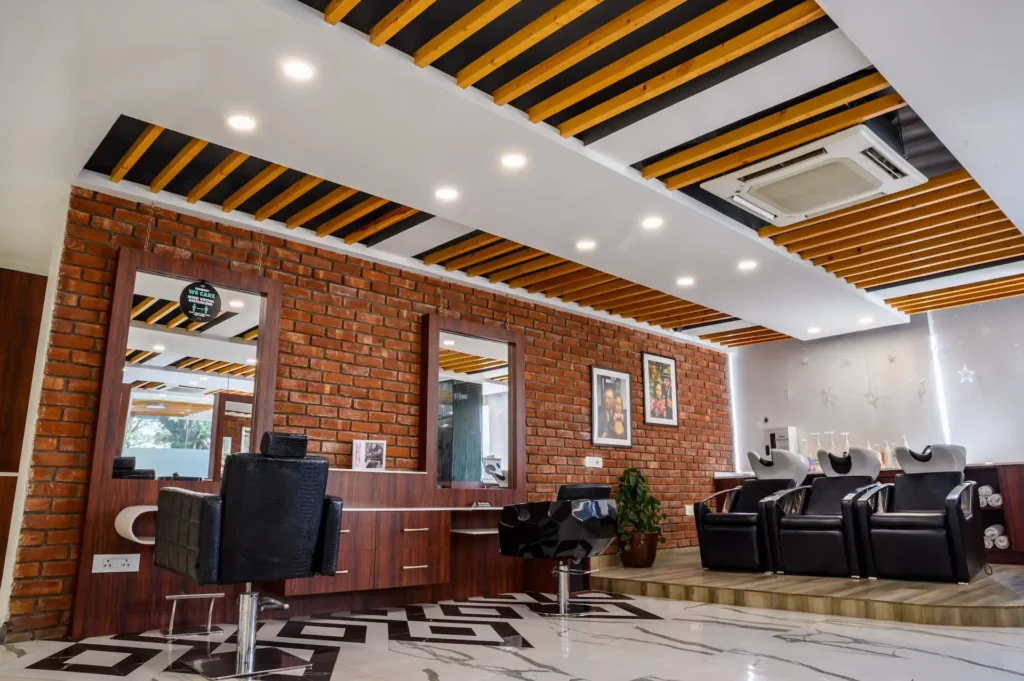 Spacious salon interior showcasing premium styling stations, brick walls, and modern lighting design.