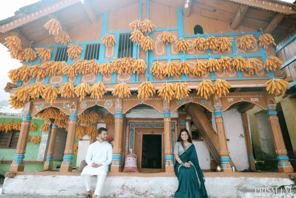 Wide view of a traditional Uttarakhand corn village house with a couple posing in front