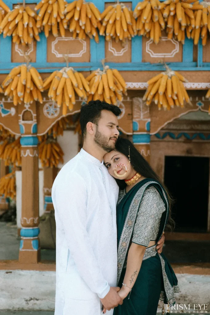 Couple standing together beneath rows of hanging corn outside an authentic heritage house