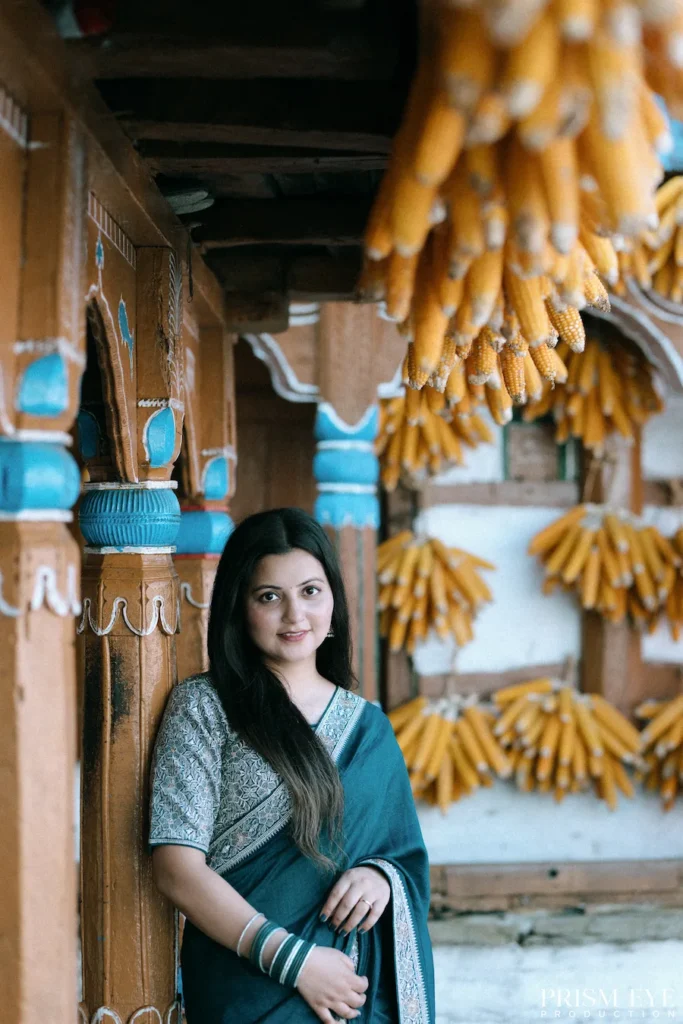Elegant portrait of a woman framed by traditional village architecture and hanging corn decorations
