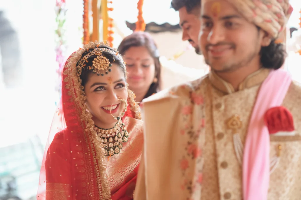 Bride smiling warmly at the groom during a traditional Hindu wedding ceremony.