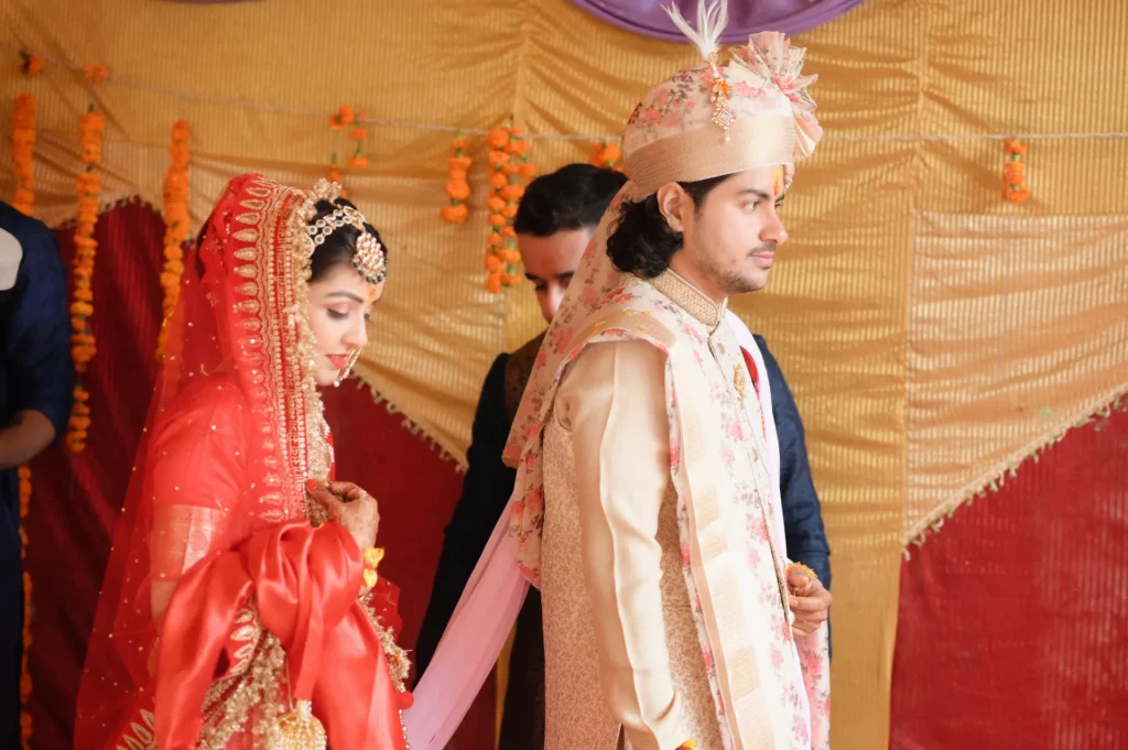 Bride and groom walking together during a traditional Indian wedding ritual.
