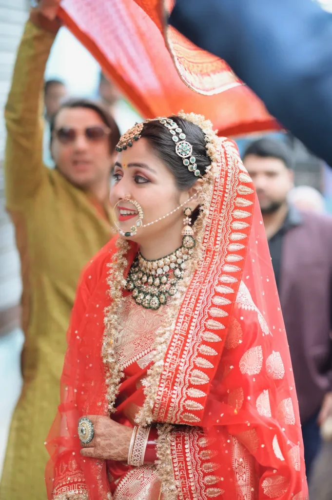 Bride smiling joyfully while participating in traditional wedding rituals with family members.