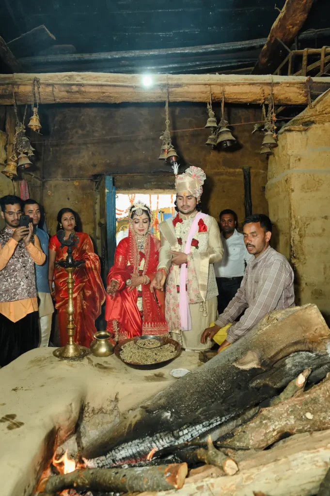 Bride and groom participating in a sacred temple ritual beside the eternal wedding flame.