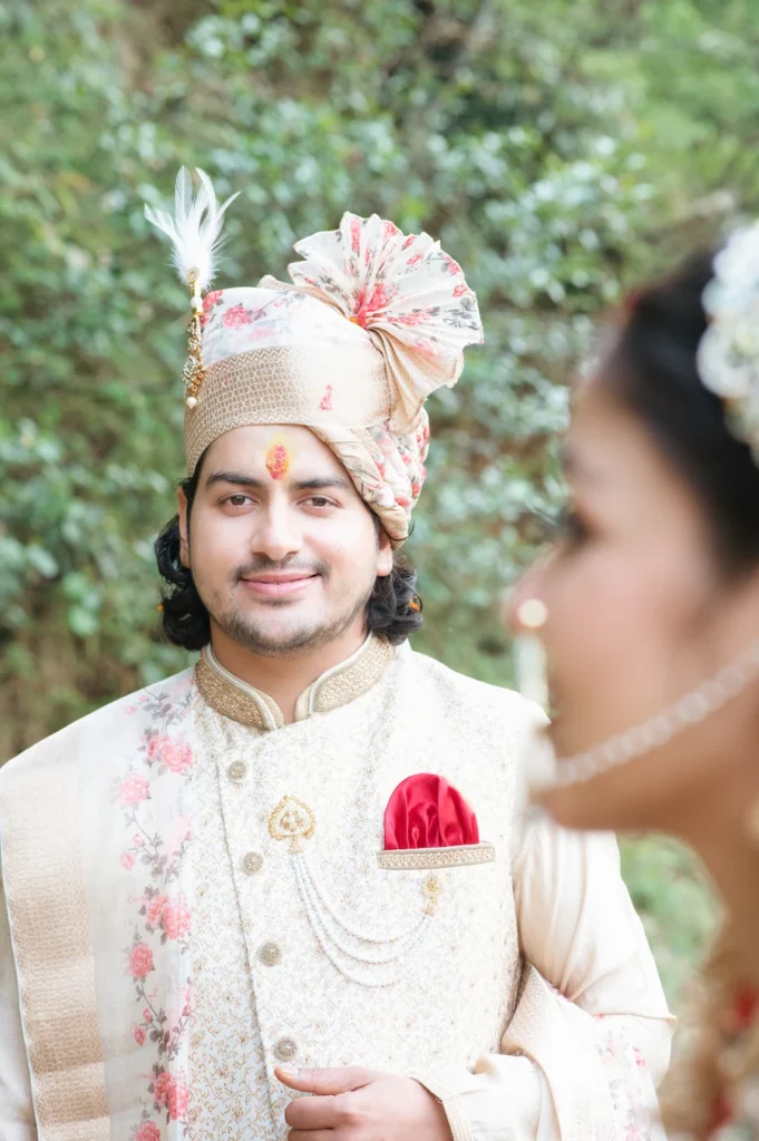 Groom smiling during the wedding ceremony while looking at the bride in a candid moment.