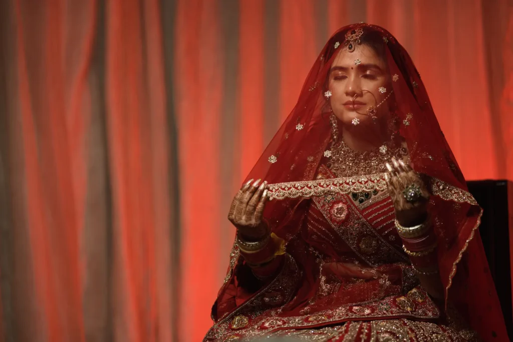 Bridal portrait in traditional red lehenga with elegant veil captured by a photographer in Dehradun