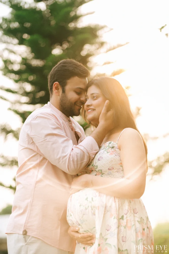 Golden hour Maternity Photoshoot capturing an intimate moment between expecting parents outdoors.