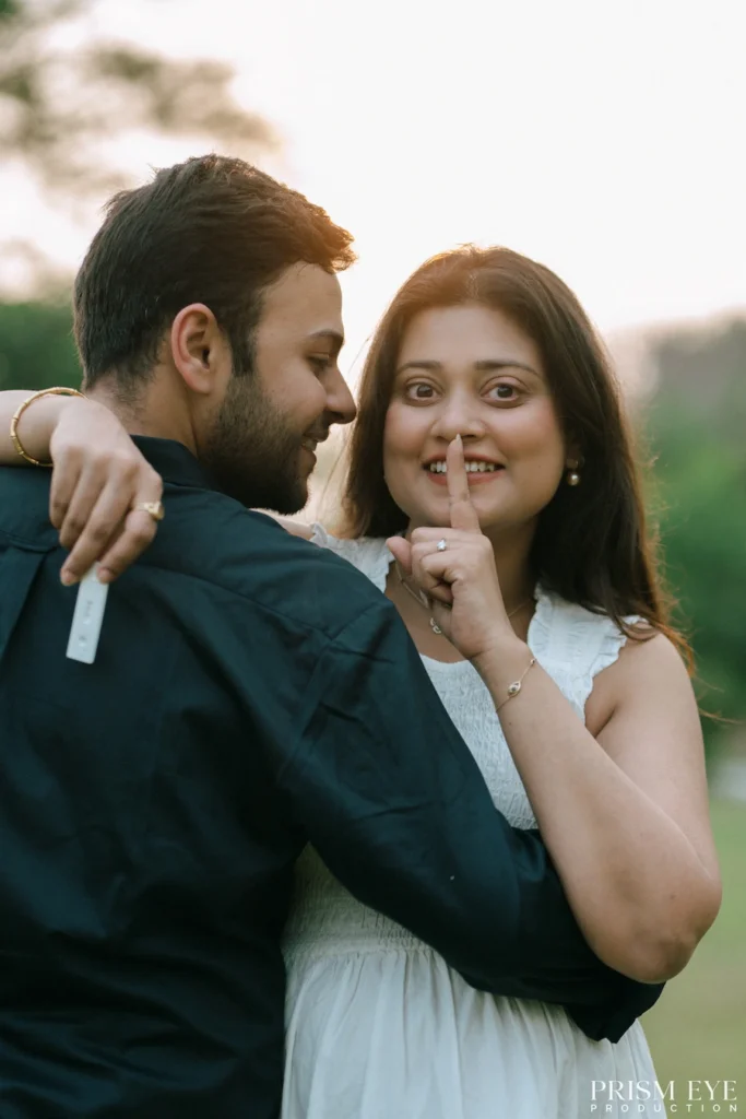 Happy expecting couple sharing a candid moment during a Maternity Photoshoot in a beautiful outdoor setting.