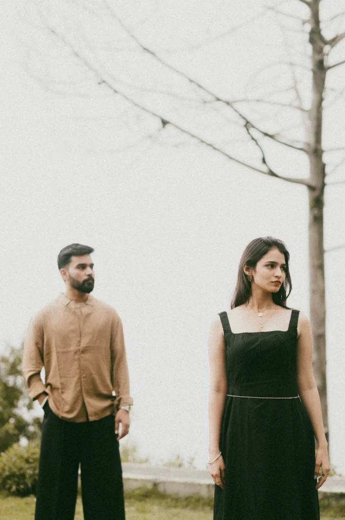 Couple standing apart in a minimalist outdoor setting with artistic composition and natural light