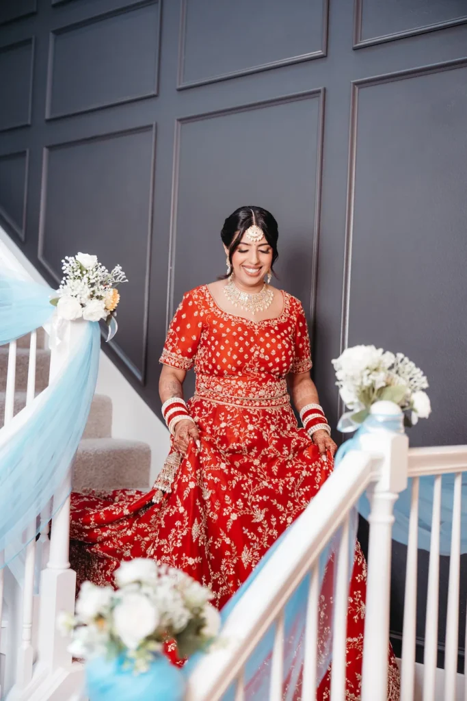 Punjabi wedding in Rishikesh bridal portrait featuring a bride in a red lehenga with traditional jewelry before the wedding ceremony