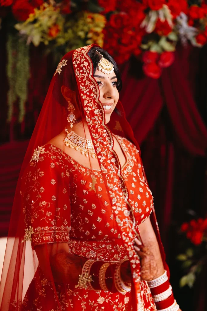Elegant bridal portrait from a Punjabi wedding in Rishikesh showcasing traditional red bridal attire and jewelry