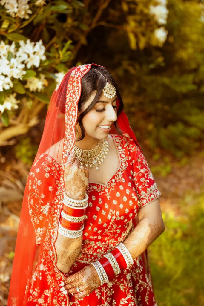 Punjabi wedding in Rishikesh bridal portrait featuring traditional red lehenga and elegant bridal jewelry