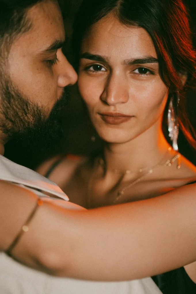 Emotional close-up portrait of a woman embracing her partner with expressive eyes and warm lighting
