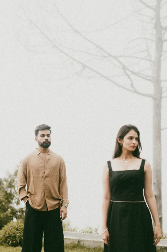 Candid portrait of a couple standing apart in a foggy landscape with a dreamy and artistic atmosphere