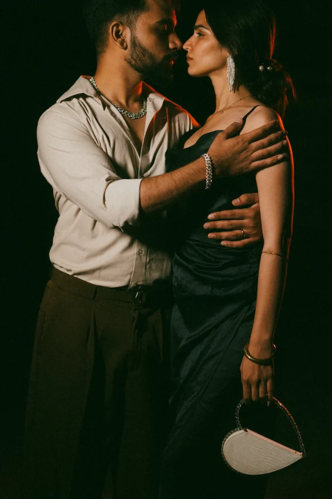Intimate evening portrait of a couple sharing a romantic moment with dramatic lighting and elegant styling