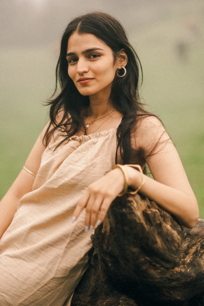 Natural portrait of a woman looking confidently at the camera with soft outdoor lighting and elegant styling